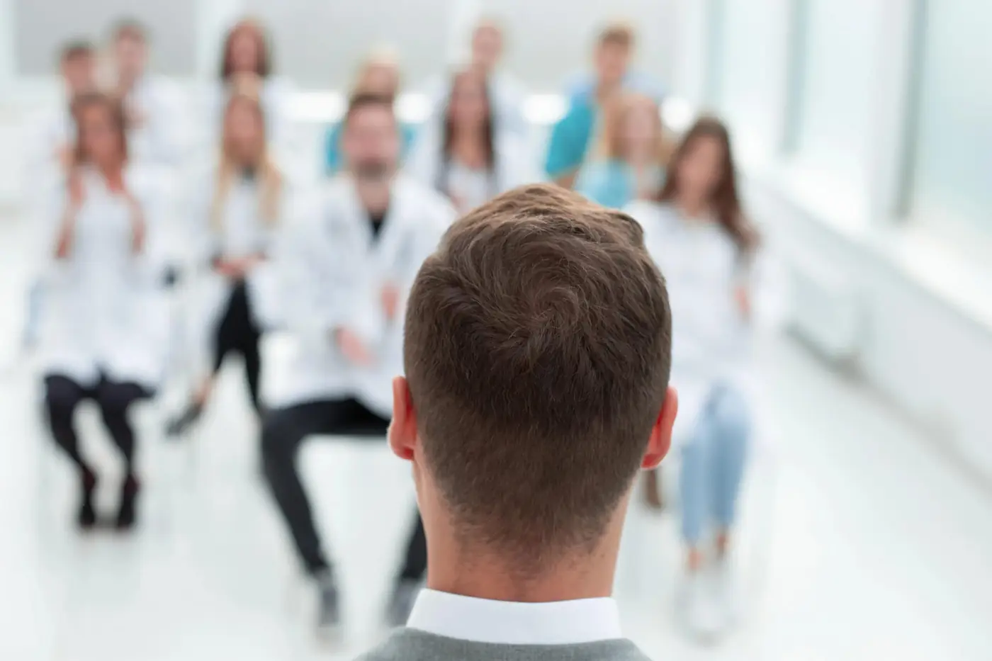 Physician addressing a group of healthcare professionals during a structured medical training session